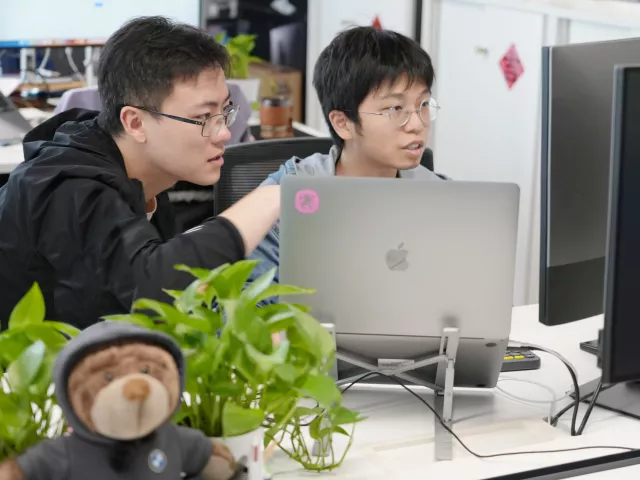 zwei-Teammitglieder-aus-Shanghai-diskutierend-am-pc