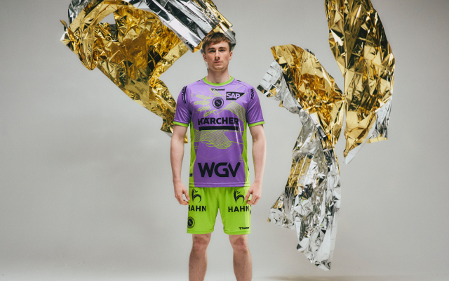maennlicher-spieler-des-tvb-stuttgarts-traegt-lila-gruenes-trikot-zum-thema-erste-hilfe-um-ihn-herrum-löschdecken