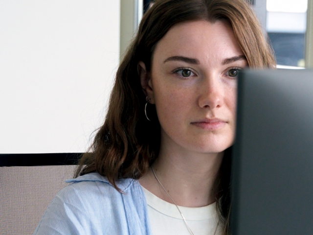 Junge-Frau-mit-braunen-Haaren-schaut-auf-Bildschirm