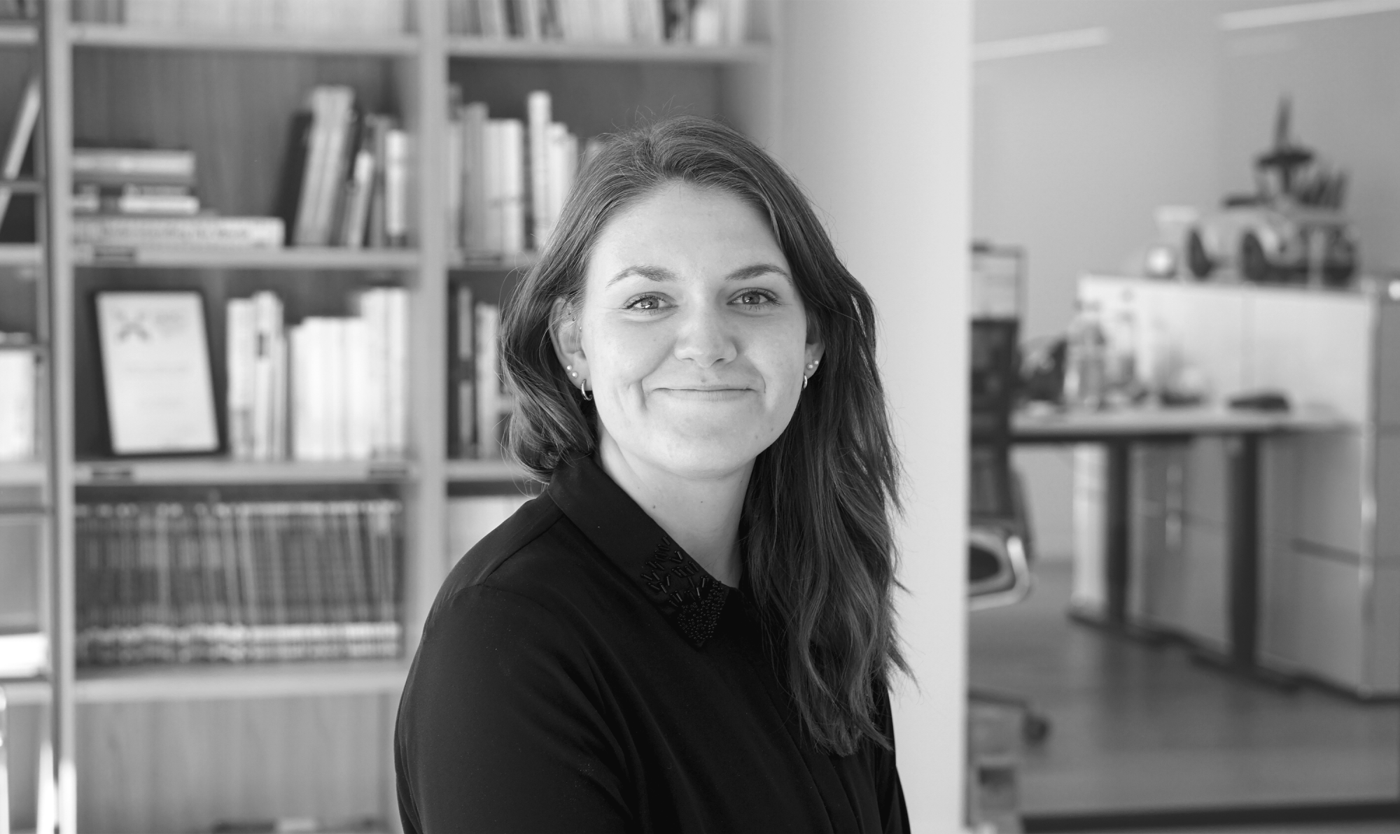 Junge-Frau-mit-langen-Haaren-laechelt-in-Kamera-schwarz-weiß-Bild