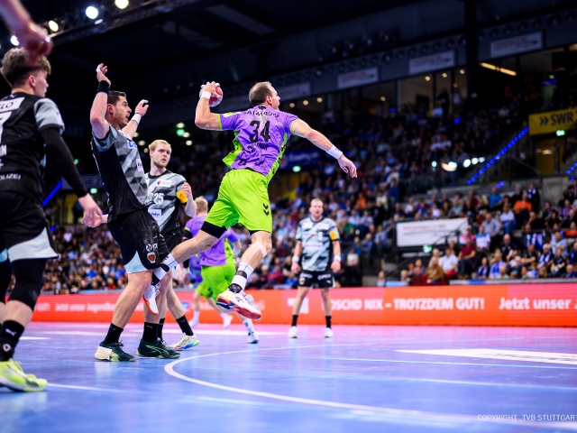 Ein-spieler-des-tvb-stuttgart-am-neun-meter-kreis-waehrend-nachhaltigkeitsspieltag-mit-lila-gruenem-trikot-von-studiokurbos