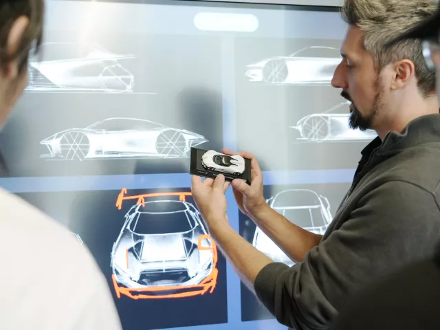 teammitglieder-mit-modellauto-disktuieren-ueber-design