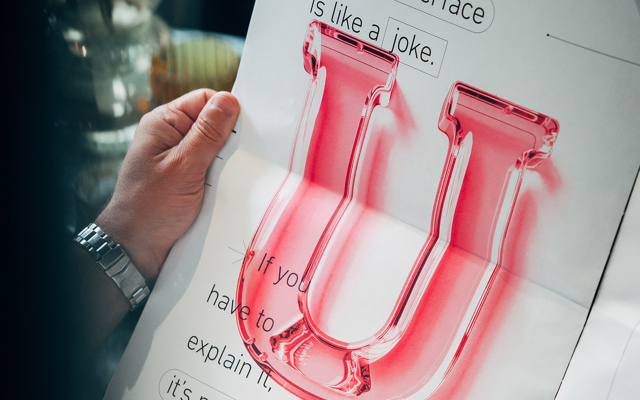 Eine-maennliche-Hand-haelt-Magazin-No-6-mit-glaesernen-U-als-Grafik-darauf