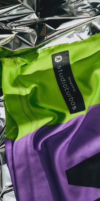 Detailfoto-des-lila-nachhaltigkeitstrikot-mit-gruenen-details-und-batch-mit-designed-by-studiokurbos